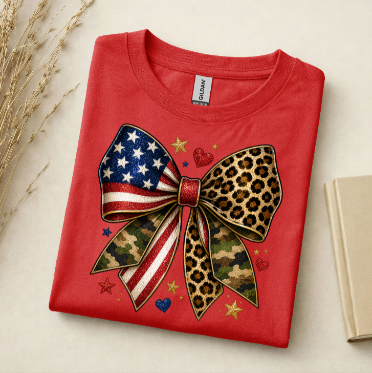 Folded red t-shirt with a large bow design featuring American flag, camouflage, and leopard print