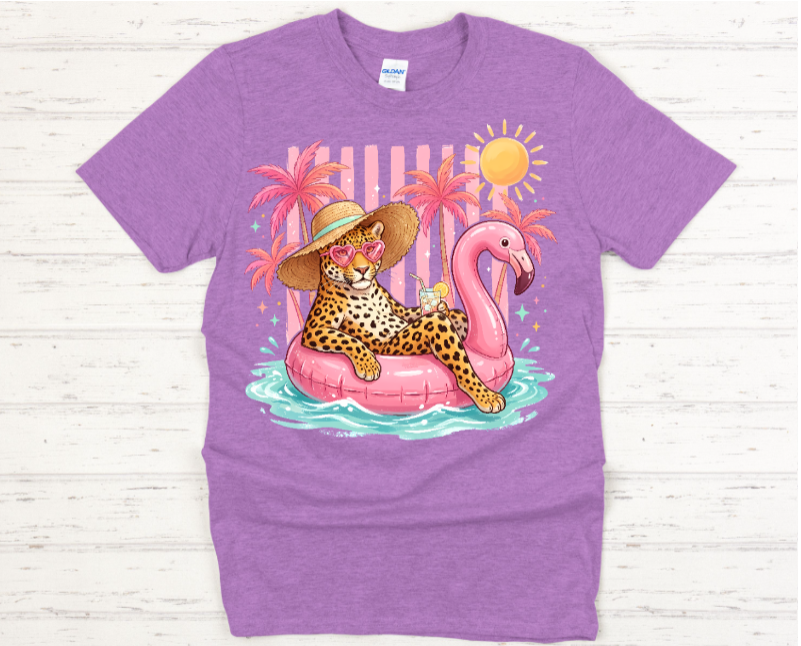 Purple t-shirt with a colorful graphic of a leopard on a pink flamingo float, palm trees, and a sun.