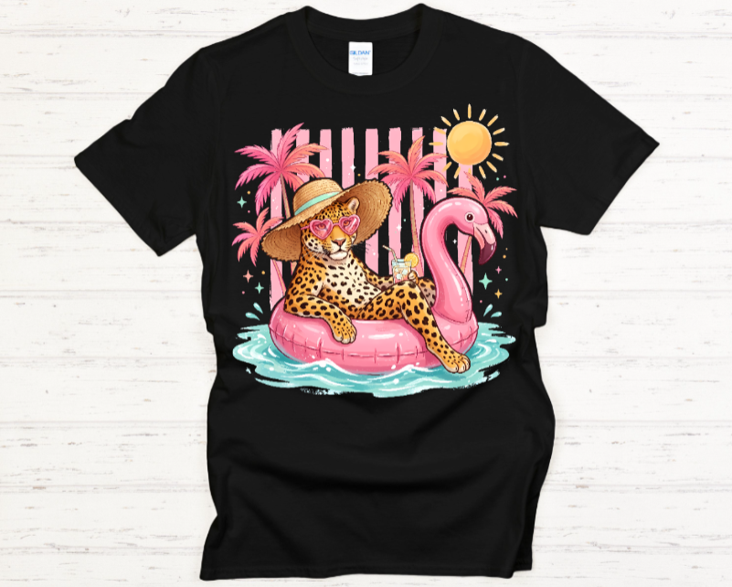 Black t-shirt with a colorful graphic of a leopard on a pink flamingo float with palm trees and a sun.